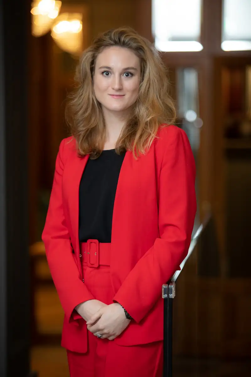 Photo portrait paris à l'intérieur en lumière naturelle d'une femme habillée en rouge
