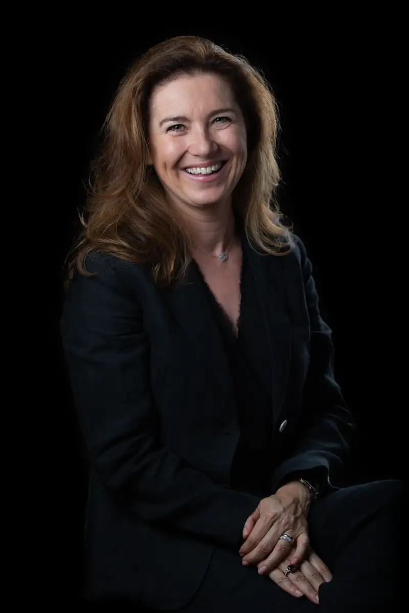 Photo portrait paris d'une femme souriante en studio avec fond noir